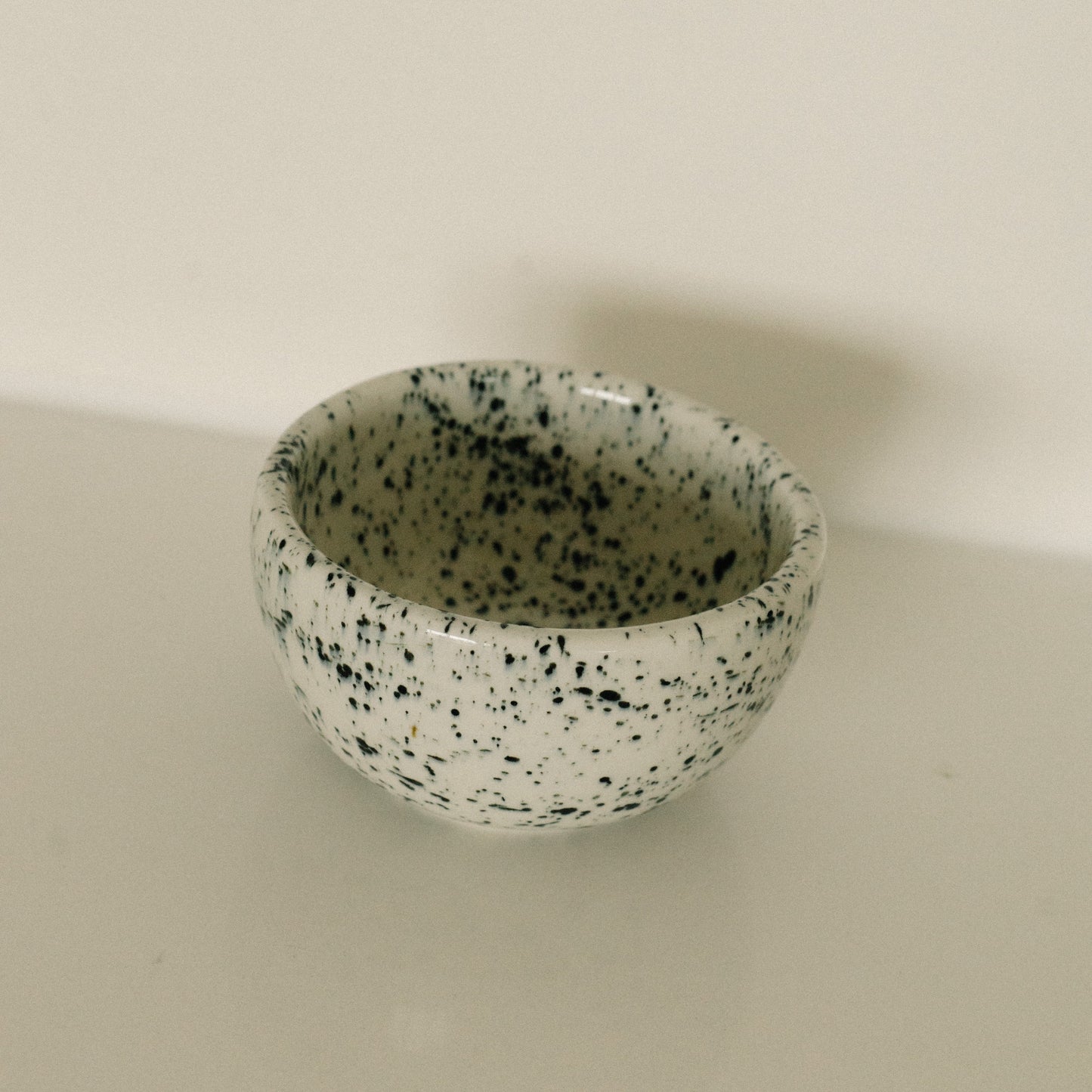 Speckled ceramic bowl on a plain background