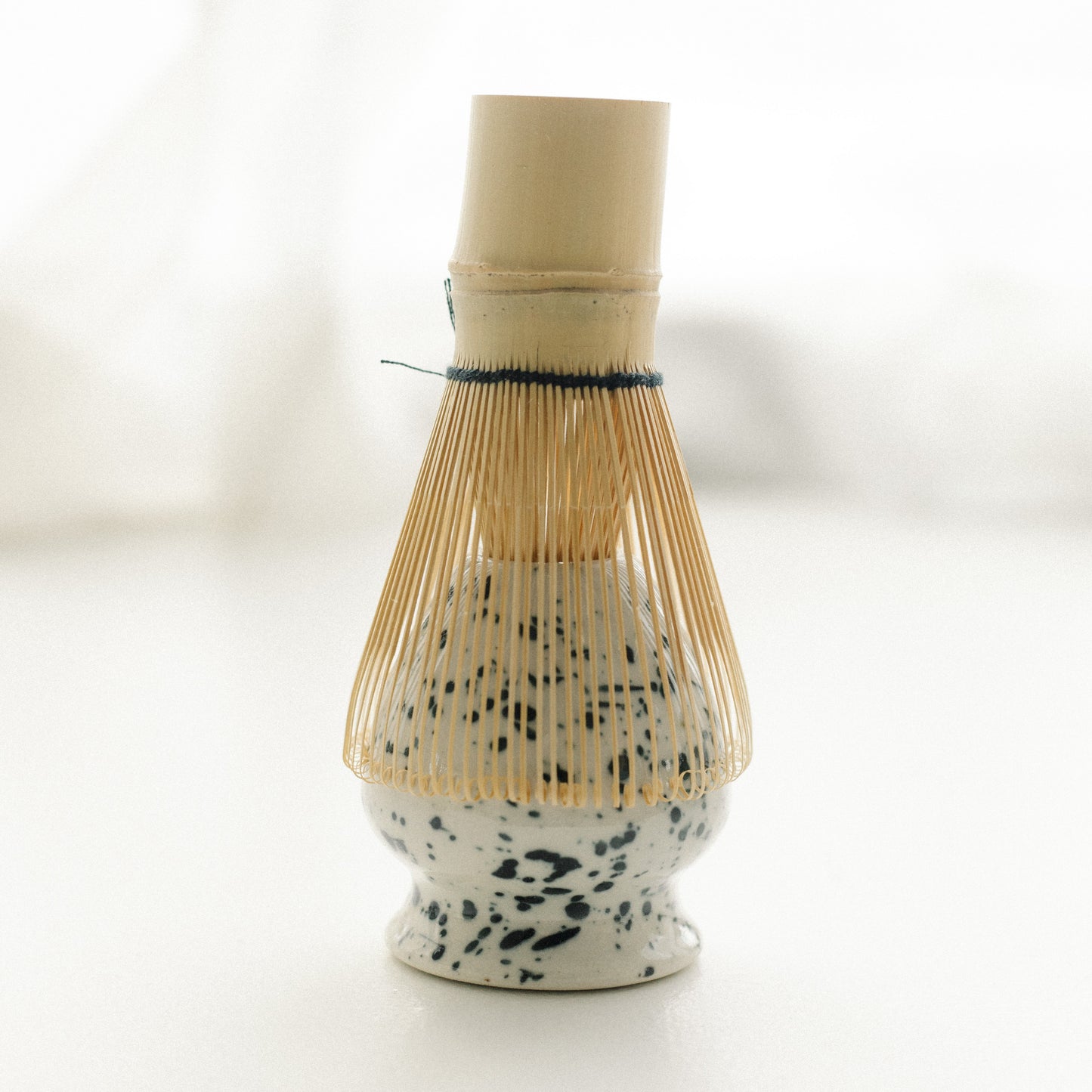 Matcha ceramic tea whisk holder with bamboo whisk on a white background