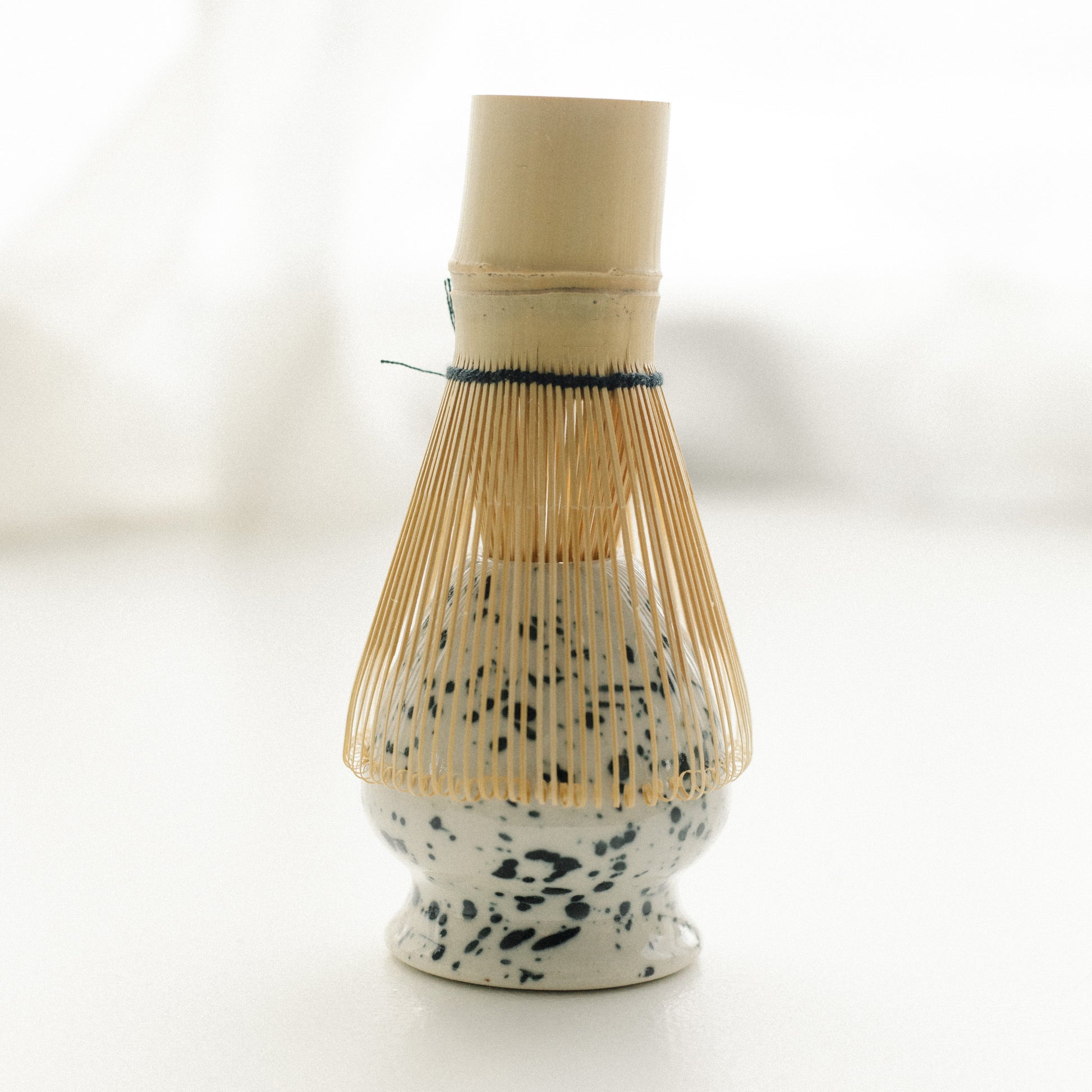 Matcha ceramic tea whisk holder with bamboo whisk on a white background